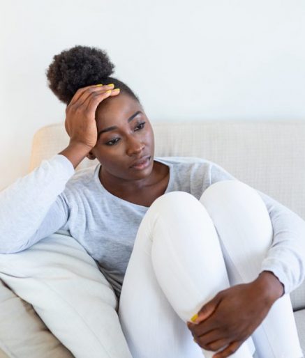 People, emotions, stress and health care concept - unhappy african american young woman touching her head and suffering from headache